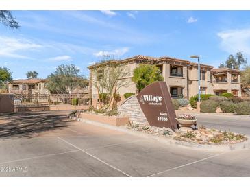 Upscale community entrance with well-manicured landscaping and multi-story residential buildings at 19700 N 76Th St # 1008, Scottsdale, AZ 85255