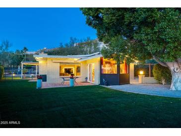 Beautiful backyard featuring a brick patio, lush green lawn and mature shade tree, perfect for outdoor living and entertaining at 2260 E Palmaire Ave, Phoenix, AZ 85020