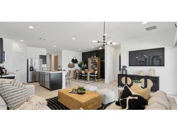 Modern open-concept living room with dining area and kitchen island, perfect for entertaining guests at 5454 E Rock Bush Ln, San Tan Valley, AZ 85140