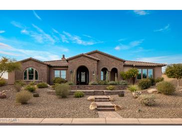 Beautiful brick home with a tile roof and meticulously maintained desert landscaping in front at 10902 N 138Th Pl, Scottsdale, AZ 85259