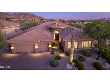 Stunning desert home with a tile roof, 3-car garage, and professionaly manicured desert landscaping at 10999 E Acoma Dr, Scottsdale, AZ 85255