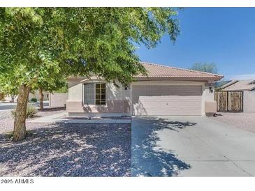 Charming single-story home with a well-maintained front yard and a two car garage at 14930 N Gil Balcome Ct, Surprise, AZ 85379