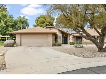 Charming single-story home featuring a well-maintained yard, two car garage and desert landscaping in front at 20215 N Medallion Ct, Sun City West, AZ 85375