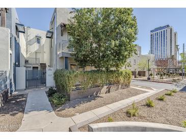 Inviting condo exterior with well-maintained landscaping, mature tree, and easy access to a nearby city street at 615 E Portland St # 160, Phoenix, AZ 85004