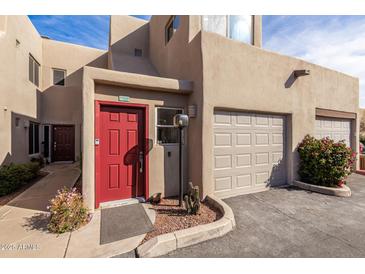 Attractive townhome showcasing a red front door, attached garage and low-maintenance landscaping at 11260 N 92Nd St # 2058, Scottsdale, AZ 85260