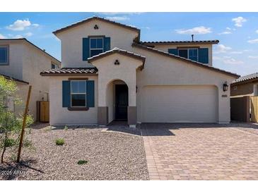 Charming two-story home featuring desert landscaping, an arched entryway, and a two-car garage at 12219 W Caraveo Pl, Peoria, AZ 85383