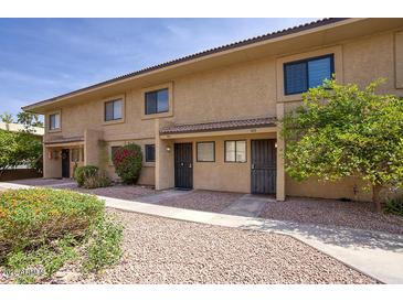 Inviting townhome exterior with well-kept landscaping and charming curb appeal on a sunny day at 12627 N La Montana Dr # 104, Fountain Hills, AZ 85268
