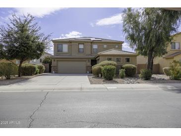 Two story home featuring landscaped front yard and three car garage at 1325 E Brent Ct, Casa Grande, AZ 85122