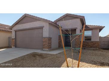 Charming single-story home featuring a two-car garage, low maintenance landscaping and neutral color palette at 17057 W Seldon Ln, Waddell, AZ 85355