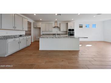 Beautiful kitchen with a large island featuring granite countertops, white cabinets, and stainless steel appliances at 17445 W Via Dona Rd, Surprise, AZ 85387