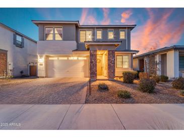 Inviting two-story home featuring a stone pillar entrance, a two car garage, and a beautiful paver driveway at 25582 S 224Th Way, Queen Creek, AZ 85142