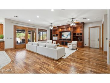 Spacious living room featuring custom built-ins, wood floors, and access to the outdoor area at 3317 E Mcdowell Rd, Mesa, AZ 85213