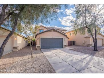 Charming two-story home featuring desert landscaping and a spacious driveway leading to a gray garage door at 3917 E Morenci Rd, San Tan Valley, AZ 85143