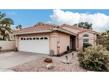 Charming single-story home featuring a two-car garage, tile roof and low maintenance landscaping at 4013 E Woodland Dr, Phoenix, AZ 85048