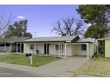 Charming single-story home with a covered porch and well-manicured lawn at 676 N 6Th Pl, Coolidge, AZ 85128