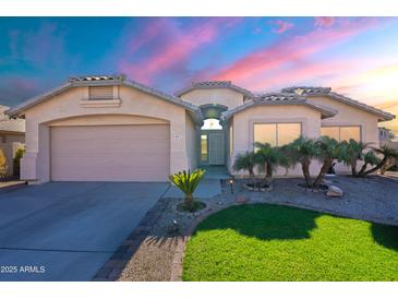 Charming single-story home with a two-car garage, desert landscaping and a colorful sunset sky at 16671 W Mckinley St, Goodyear, AZ 85338