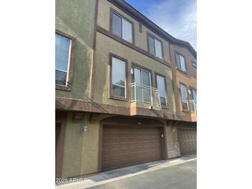 Townhouse exterior view featuring a balcony, garage, and stucco facade at 1920 E Bell Rd # 1188, Phoenix, AZ 85022