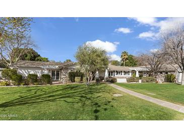 Charming single-story home with a well-manicured lawn and inviting stone pathway at 1018 W Kaler Dr, Phoenix, AZ 85021