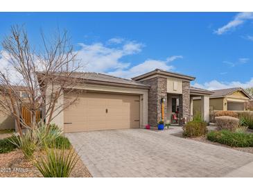 Charming home featuring desert landscaping, stone accents, and a spacious driveway at 11558 W Levi Dr, Avondale, AZ 85323