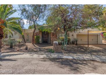 Charming single-story home featuring a stone entrance, desert landscaping, and an inviting facade at 3229 E Malapai Dr, Phoenix, AZ 85028