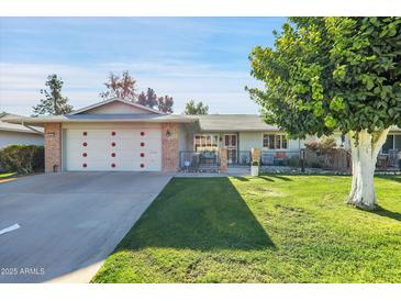 Inviting single-story home with well-kept lawn, charming curb appeal, and a two-car garage at 10825 W Caron Dr, Sun City, AZ 85351