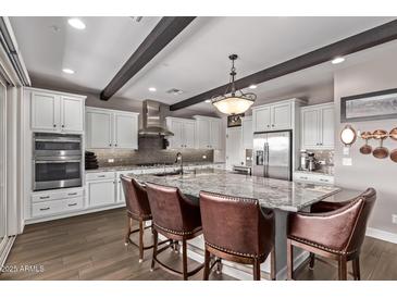 Bright kitchen with island seating, stainless steel appliances, and abundant counter space at 13211 W Hummingbird Ter, Peoria, AZ 85383