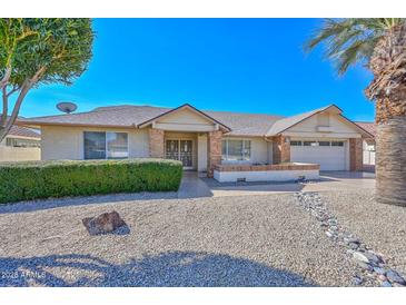 Charming single-story home with desert landscaping, brick accents, and a well-manicured front yard under a clear blue sky at 14617 W Windcrest Dr, Sun City West, AZ 85375