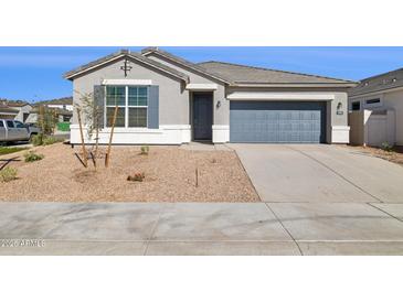 Charming single-story home with a well-maintained front yard and a two-car garage at 17792 W Onyx Ave, Waddell, AZ 85355