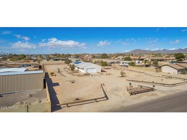 Wide aerial shot of home with white exterior, solar panels, large yard, and mountain views at 2038 S 221St Ave, Buckeye, AZ 85326