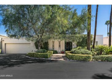 Charming single-story home with mature trees and a well-manicured front yard at 5642 N Scottsdale Rd, Paradise Valley, AZ 85253