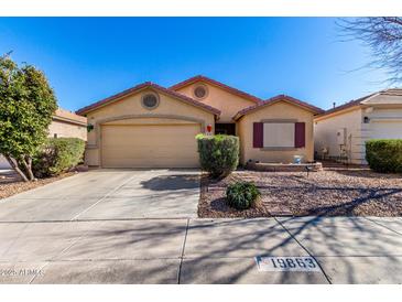 Charming single-story home featuring a well-manicured yard and attached two-car garage at 19863 N Emmerson Dr, Maricopa, AZ 85138