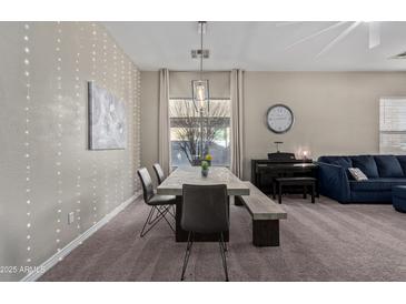 Bright dining area features a modern table, art, and string lights for a cozy and stylish gathering space at 3344 E Grand Canyon Dr, Chandler, AZ 85249