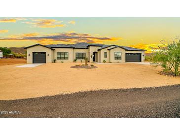 Beautiful single-story home showcasing a neutral palette, dark roof, desert landscaping, and two-car garage at 39705 N 3Rd St, Phoenix, AZ 85086