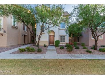Charming townhome featuring a landscaped front yard with mature trees and a welcoming front entrance at 5619 S 21St Pl, Phoenix, AZ 85040