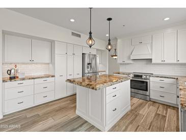 Bright kitchen featuring white cabinetry, a subway tile backsplash and granite countertops at 8340 E Rowel Rd, Scottsdale, AZ 85255