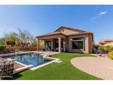 A beautiful backyard pool and patio area featuring lush green grass, perfect for outdoor entertaining at 1633 N Woodruff --, Mesa, AZ 85207