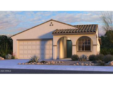 Charming single-story home with a tile roof, arched entryway, and a well-manicured desert landscape at 16800 W Hope Dr, Surprise, AZ 85388