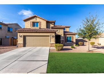 Two-story home featuring a neutral stucco facade, two-car garage, and well-manicured front lawn at 17474 W Straight Arrow Ln, Surprise, AZ 85387
