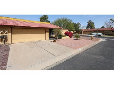 Charming single-story home with a well-maintained yard, attached garage, and vibrant landscaping at 4916 E Hopi St, Phoenix, AZ 85044