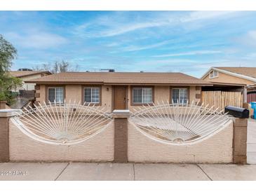 Charming single-story home featuring a decorative front fence and well-maintained front yard at 7017 W Beatrice St, Phoenix, AZ 85043