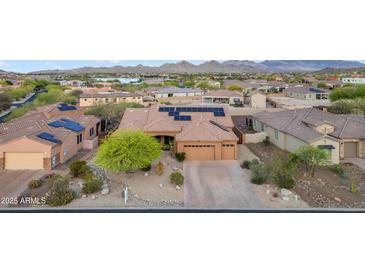 Attractive aerial view of a home with solar panels, desert landscaping, mountain and lake views at 10931 S Santa Columbia Dr, Goodyear, AZ 85338