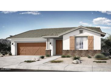 Charming single-story home featuring a two-car garage, brick accents, and desert-friendly landscaping in the front yard at 14777 W Soft Wind Dr, Surprise, AZ 85387