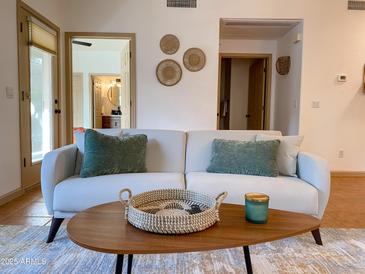 Cozy living room featuring a comfortable sofa, stylish coffee table, and decorative wall art at 16545 E Gunsight Dr # 103, Fountain Hills, AZ 85268