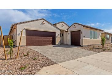 Charming home featuring a well-manicured yard, brick driveway, and three-car garage at 25215 N 131St Dr, Peoria, AZ 85383