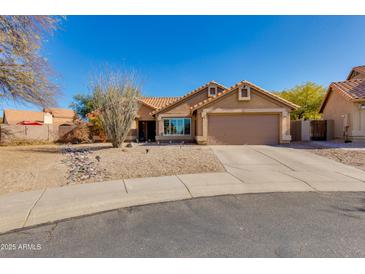 Charming single-story home with a two car garage and low maintenance desert landscaping under a clear blue sky at 4044 E Cascalote Dr, Cave Creek, AZ 85331