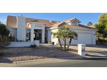 Charming single-story home featuring a well-manicured front yard and a two-car garage at 10549 E Cedar Waxwing Dr, Sun Lakes, AZ 85248