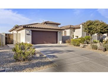 Charming home featuring a spacious driveway, desert landscaping, and a two-car garage at 17634 W Verdin Rd, Goodyear, AZ 85338