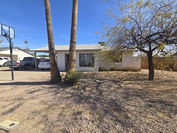 Charming single-story home with a gravel front yard, mature trees, covered parking, and a basketball hoop at 3031 S Los Altos --, Mesa, AZ 85202