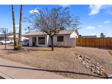 Charming single story house with a gravel yard and a mature tree, under a blue sky with white clouds at 3031 S Los Altos --, Mesa, AZ 85202