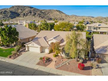 Stunning aerial view of a single-Gathering home with a three car garage, mature landscaping and mountain views at 3144 E Desert Broom Way, Phoenix, AZ 85048